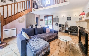 A spacious living area with a blue sofa, a small white table, and a fireplace. - Lovely home in Carlux with heated swimming pool (Carlux)
