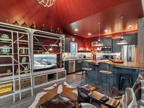 A modern kitchen with a central island, bar seating, and a large window overlooking a snowy landscape. - Midway 447 | Golf Views | Gym | Pool & Hot Tub | Near Deer Valley (Midway)