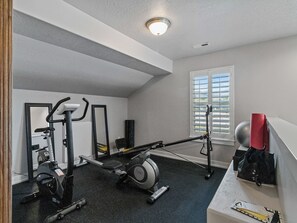 A gym with exercise equipment, a window with blinds, and a ceiling light. - Midway 447 | Golf Views | Gym | Pool & Hot Tub | Near Deer Valley (Midway)