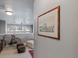 A room with a bicycle, a framed picture on the wall, and a window with a view. - Midway 447 | Golf Views | Gym | Pool & Hot Tub | Near Deer Valley (Midway)