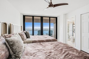 A bedroom with a large window, a ceiling fan, and a view of a body of water. - ⭐CBC 1-20E | Penthouse beachfront condo with Gulf views, 2BR/2BA, pool, gym, and balcony. (Clearwater Beach)