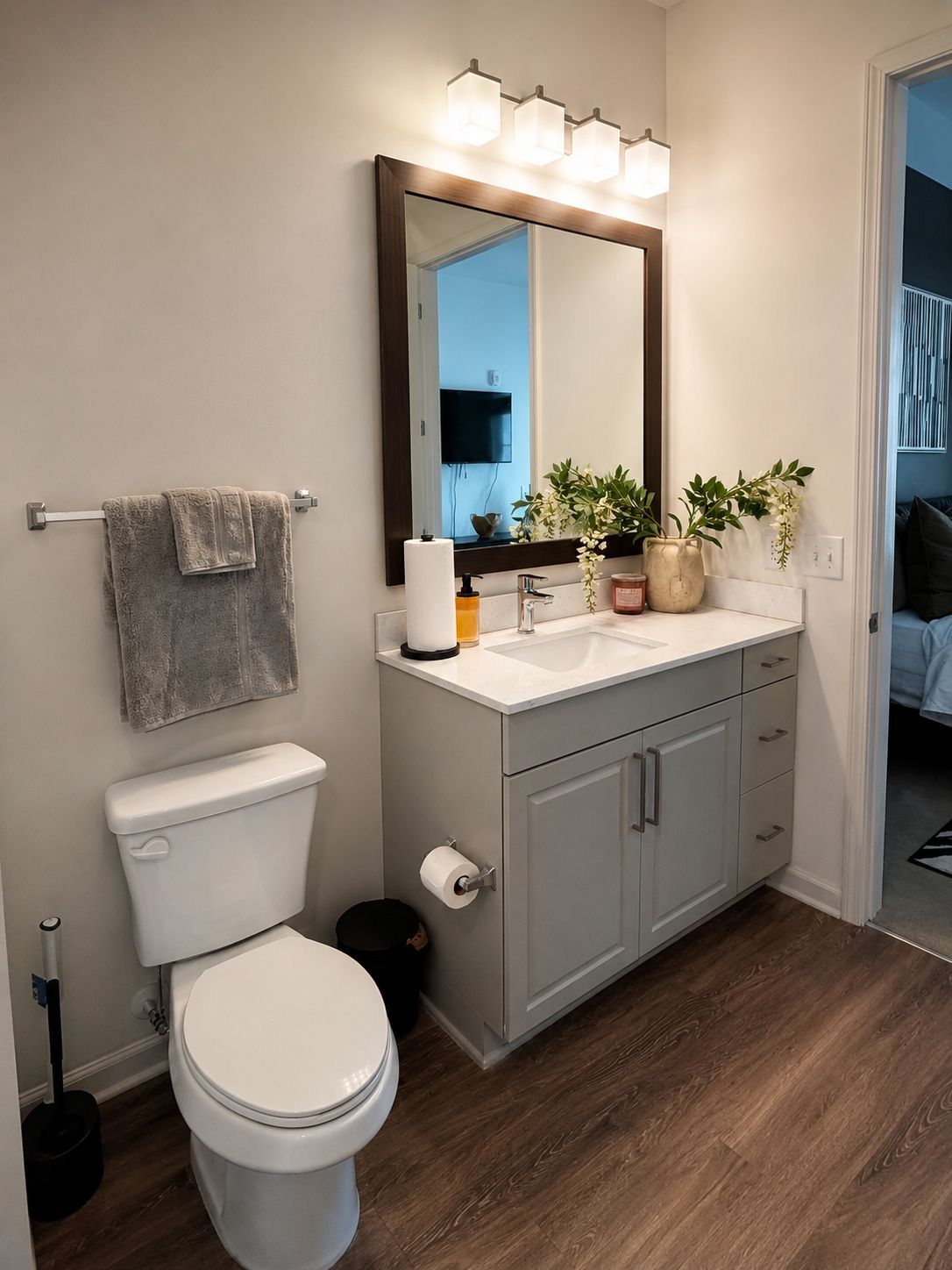 A modern bathroom with a toilet, sink, and mirror.