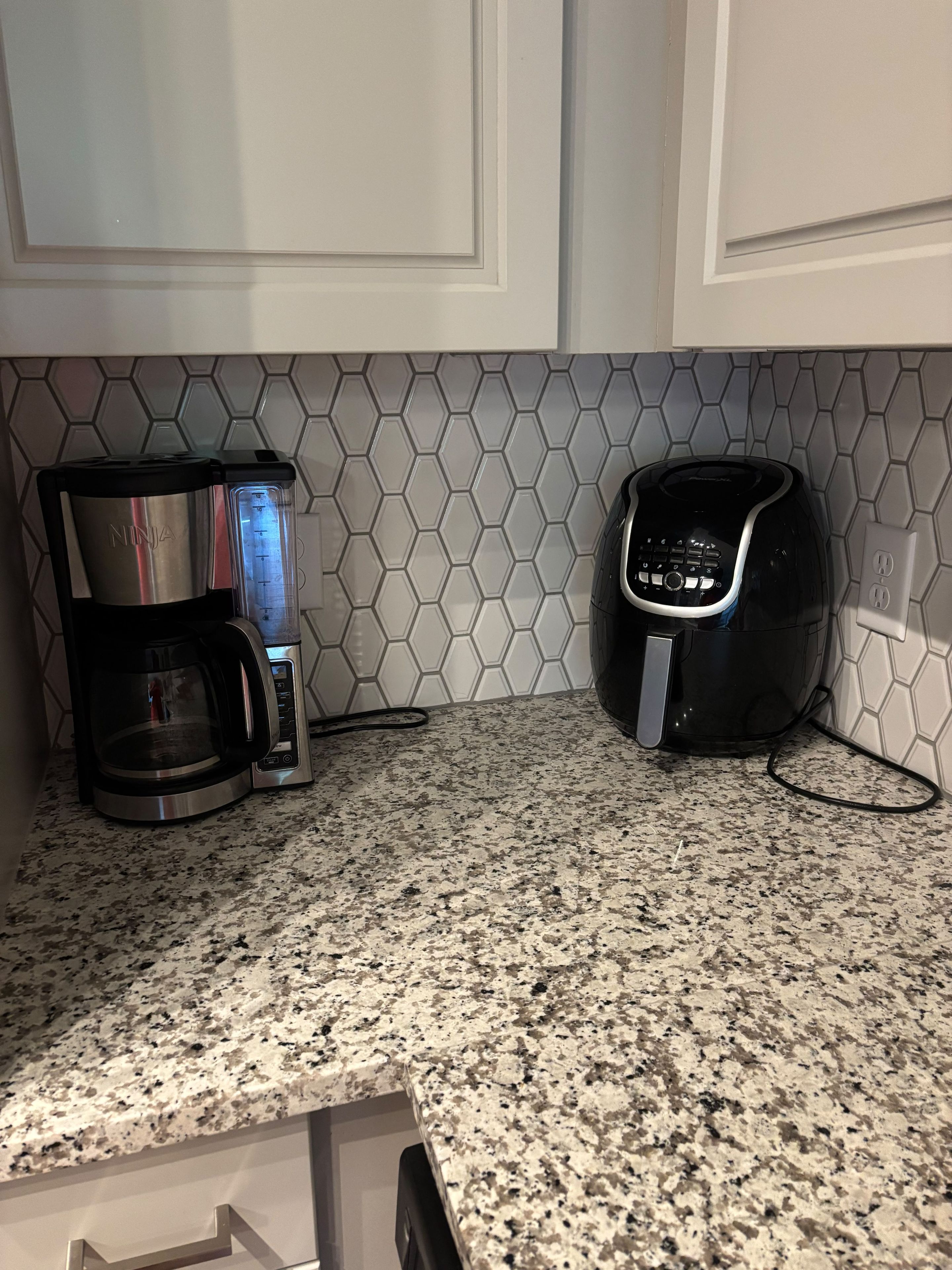 Een keuken met een koffiezetapparaat en een broodrooster op een granieten aanrecht.