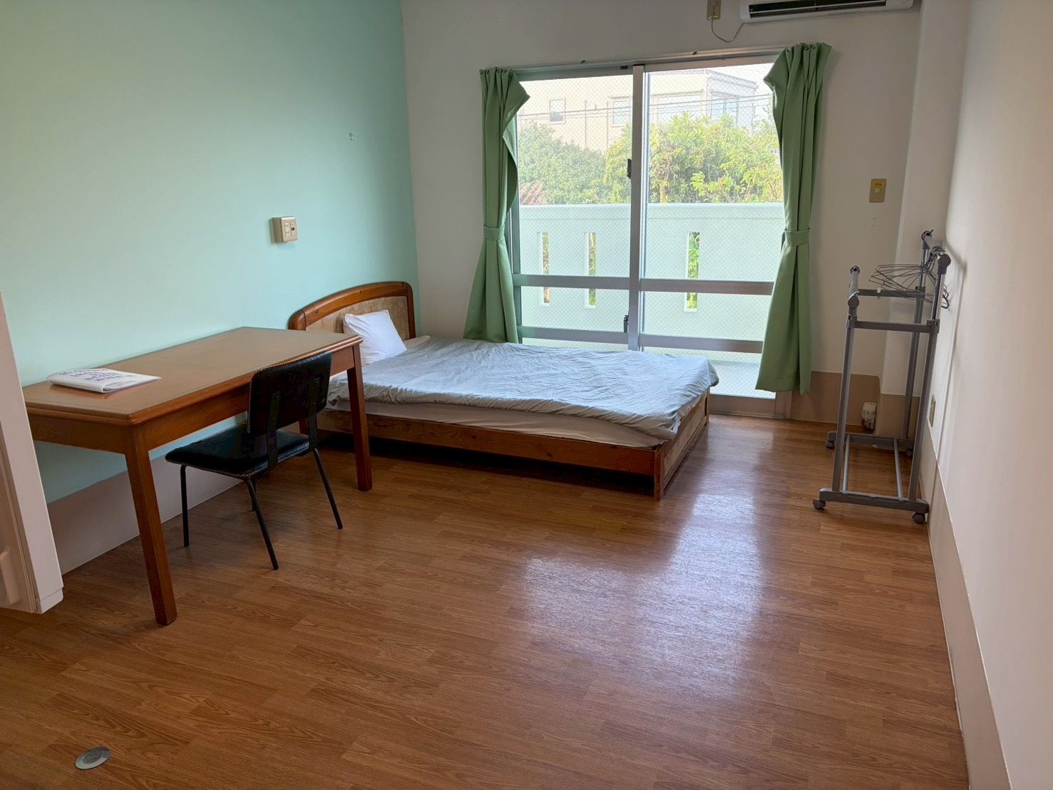 A room with a bed, a desk, and a chair.