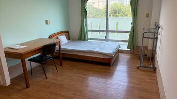 A room with a bed, a desk, and a chair.