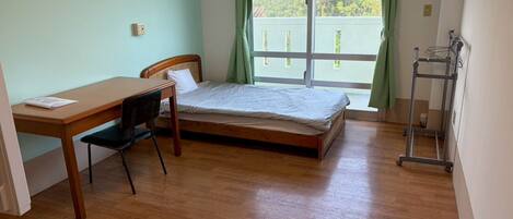 A room with a bed, a desk, and a chair.