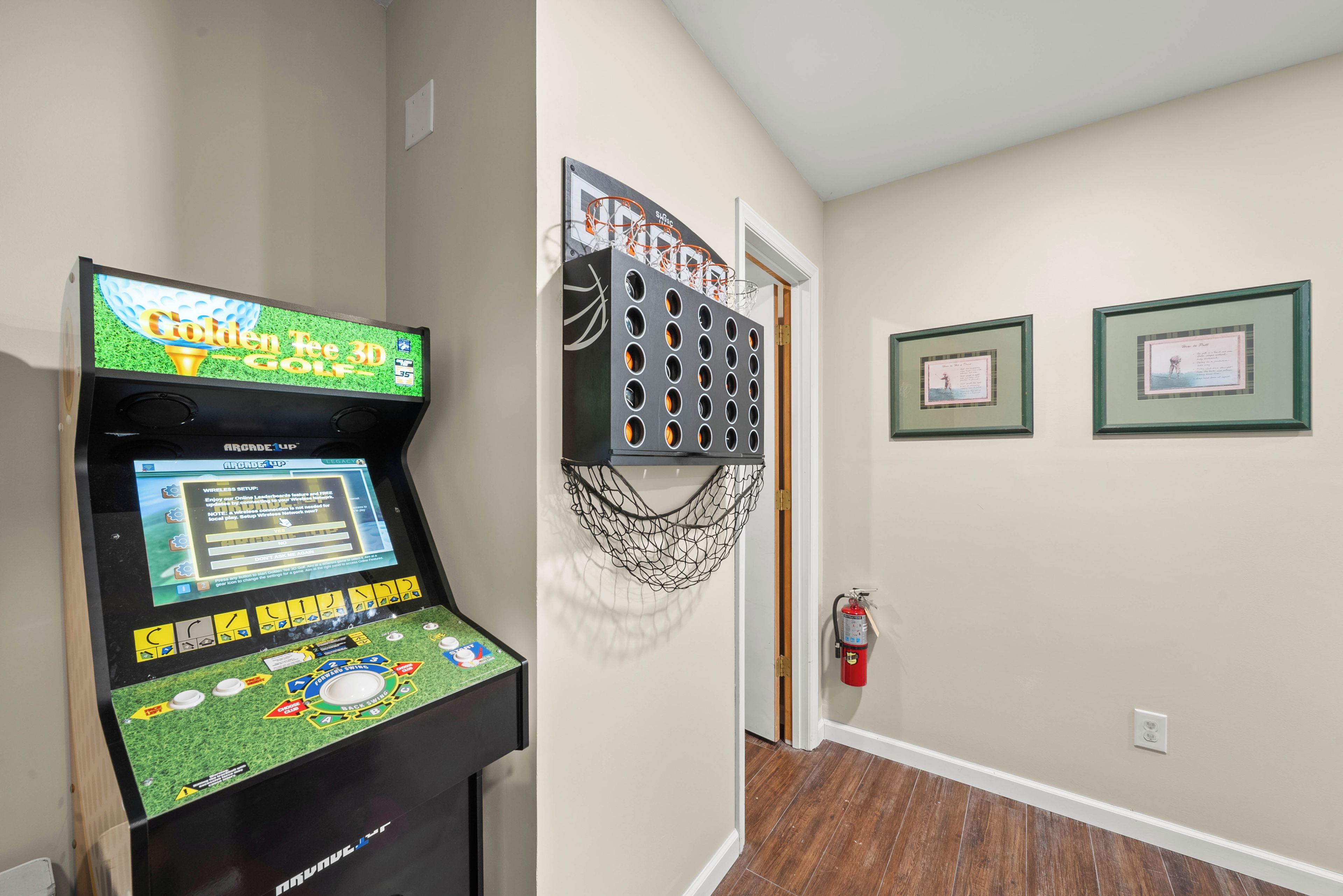 A bowling alley with a digital scoreboard, a bowling ball return system, and a fire extinguisher.