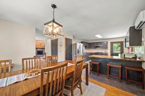 A modern kitchen with a central island, wooden dining table, and chairs. - Cozy High Country Cabin Near Banner Elk (Banner Elk)