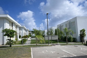 Ein modernes Wohngebäude mit Parkplätzen und blauem Himmel.