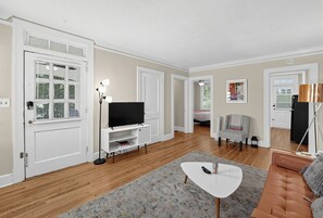 A living room with a flat-screen TV, a white coffee table, a sofa, and a chair. - Cloverdale Retreat 327 (Montgomery)