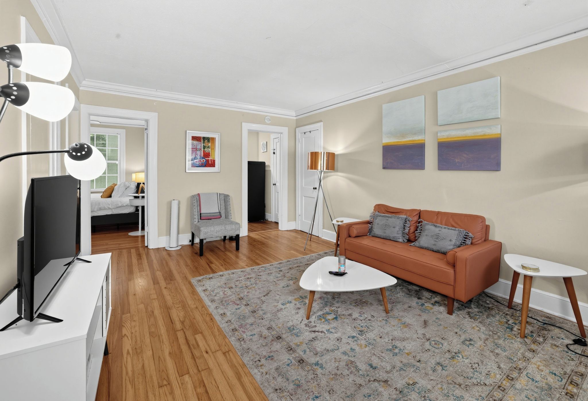 A modern living room with a sofa, coffee table, and a TV on a stand.