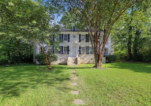 A two-story house with a front porch and a lawn.