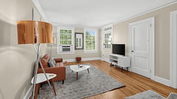 A modern living room with a sofa, coffee table, and TV stand.