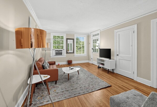 A modern living room with a sofa, coffee table, and TV stand.