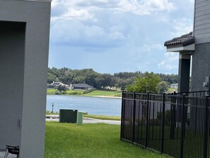 A residential area with a view of a lake, a fenced yard, and houses in the background. - Villa Wonderlands! in the CENTRAL FLORIDA INNOVATION DISTRIC 30 MIN FROM DISNEY! (Auburndale)