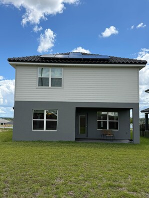 A two-story house with a flat roof, a front porch, and a small outdoor seating area. - Villa Wonderlands! in the CENTRAL FLORIDA INNOVATION DISTRIC 30 MIN FROM DISNEY! (Auburndale)