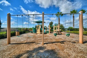 A playground with swings and climbing structures. - Villa Wonderlands! in the CENTRAL FLORIDA INNOVATION DISTRIC 30 MIN FROM DISNEY! (Auburndale)
