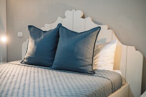 A bed with a patterned bedspread and two pillows.