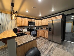 Une cuisine moderne avec des meubles en bois, des appareils en acier inoxydable et un plan de travail en granit.