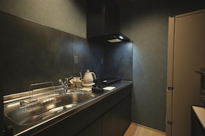 Een moderne keuken met een rvs-spoelbak, een waterkoker en een broodrooster op het aanrecht.