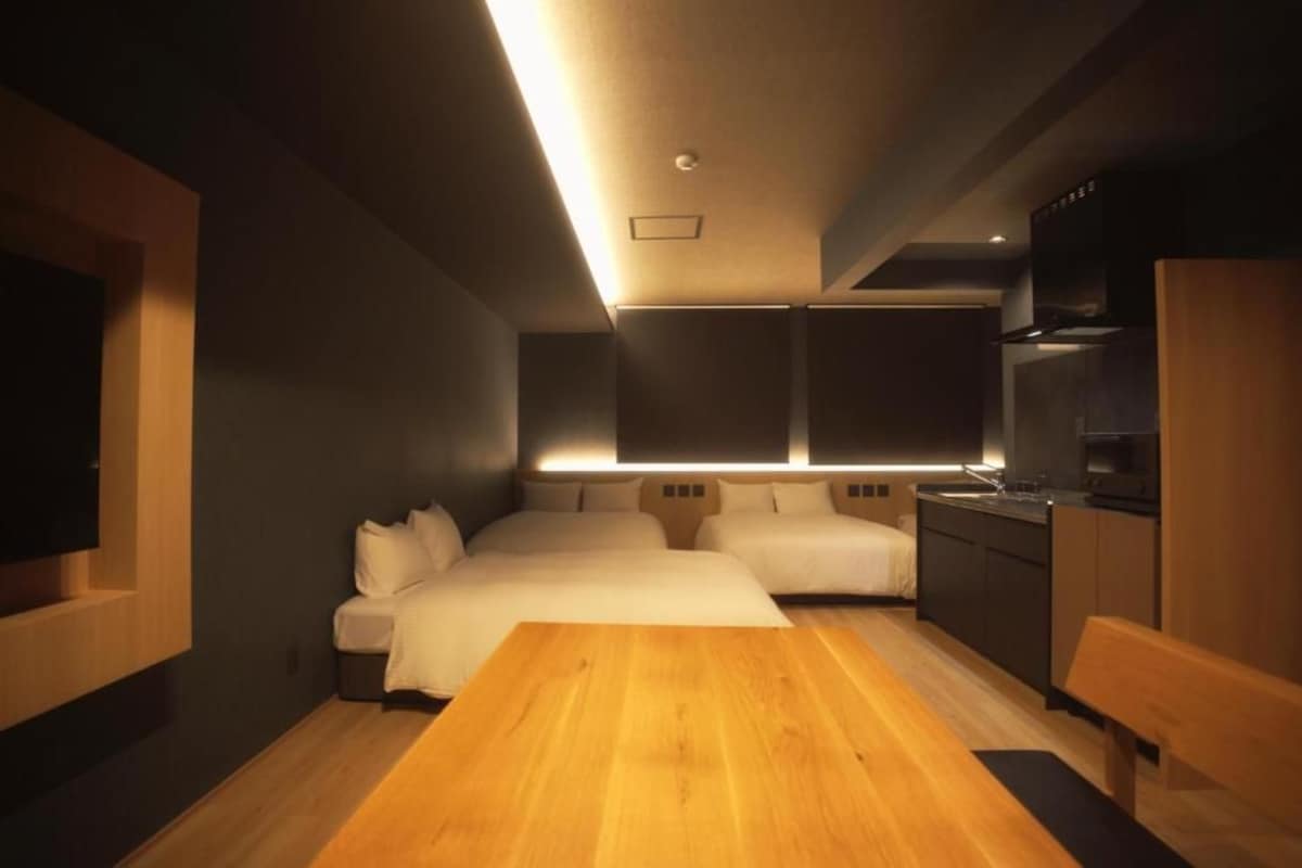 Een moderne slaapkamer met een houten bed, nachtkastjes en een ingebouwde televisie.