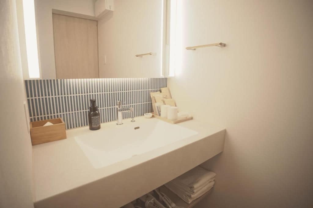A bathroom with a white sink, a mirror, and a towel rack.
