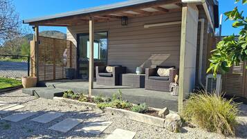 A modern outdoor seating area with wicker furniture and a concrete floor.