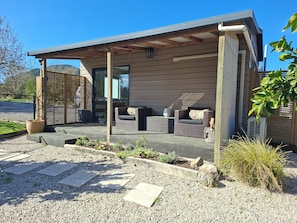 A modern outdoor seating area with wicker furniture and a concrete floor.