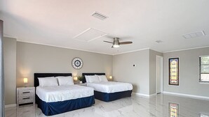 A hotel room with two beds, a ceiling fan, a clock, and a stained glass window. - Northshore Waterfront Resort (Port Charlotte)
