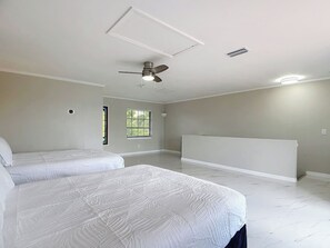 A spacious room with two beds, a ceiling fan, and a large window. - Northshore Unobstructed View 5BR 4BA Sleep 16 (Port Charlotte)
