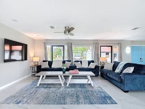A modern living room with a sofa set, a coffee table, and a ceiling fan. - Northshore Waterfront Resort (Port Charlotte)