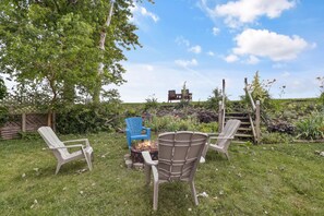 An outdoor seating area with chairs and a fire pit. - Modern 3‑Bedroom Lake House with Gorgeous Water & Wildlife Views (Toledo)