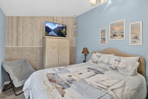 A bedroom with a bed, a television on a cabinet, a lamp, and three framed pictures on the wall. - Modern 3‑Bedroom Lake House with Gorgeous Water & Wildlife Views (Toledo)