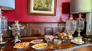 Een bar met een rode muur, een ingelijst kunstwerk en diverse etenswaren op het aanrecht.