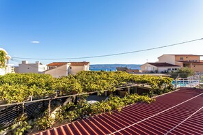 A rooftop with a red roof, a vineyard, and a view of the sea. - A5 - Apartment w pool, terrace and sea view (Dugi Rat)