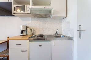 A compact kitchenette with a built-in microwave, a coffee maker, a stove, and a sink. - A5 - Apartment w pool, terrace and sea view (Dugi Rat)
