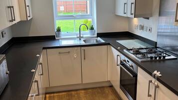 A modern kitchen with a sink, stove, and cabinets.