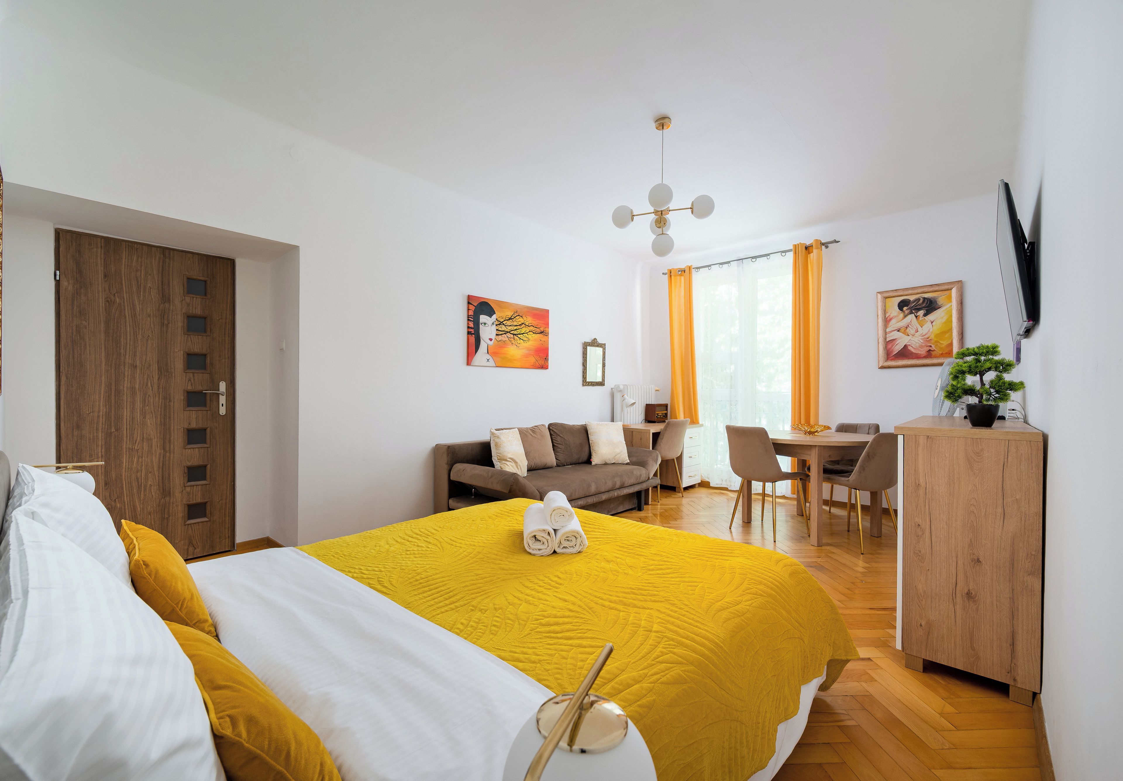 Une chambre d’hôtel moderne équipée d’un lit, d’un bureau, d’un canapé et d’un coin repas.