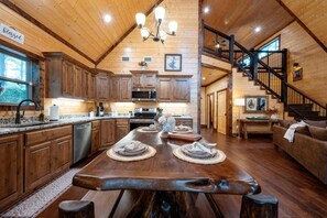 A spacious kitchen with wooden cabinets, a large island, and a dining area with a bench.
