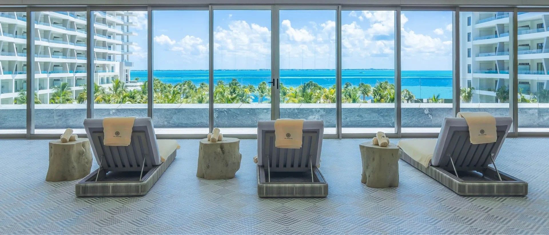 Habitación con vista al océano, con cuatro sillones de descanso y una mesita.