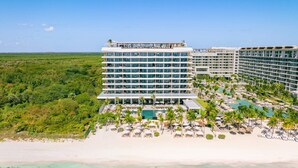 Um hotel com vários andares, área de piscina e acesso à praia.