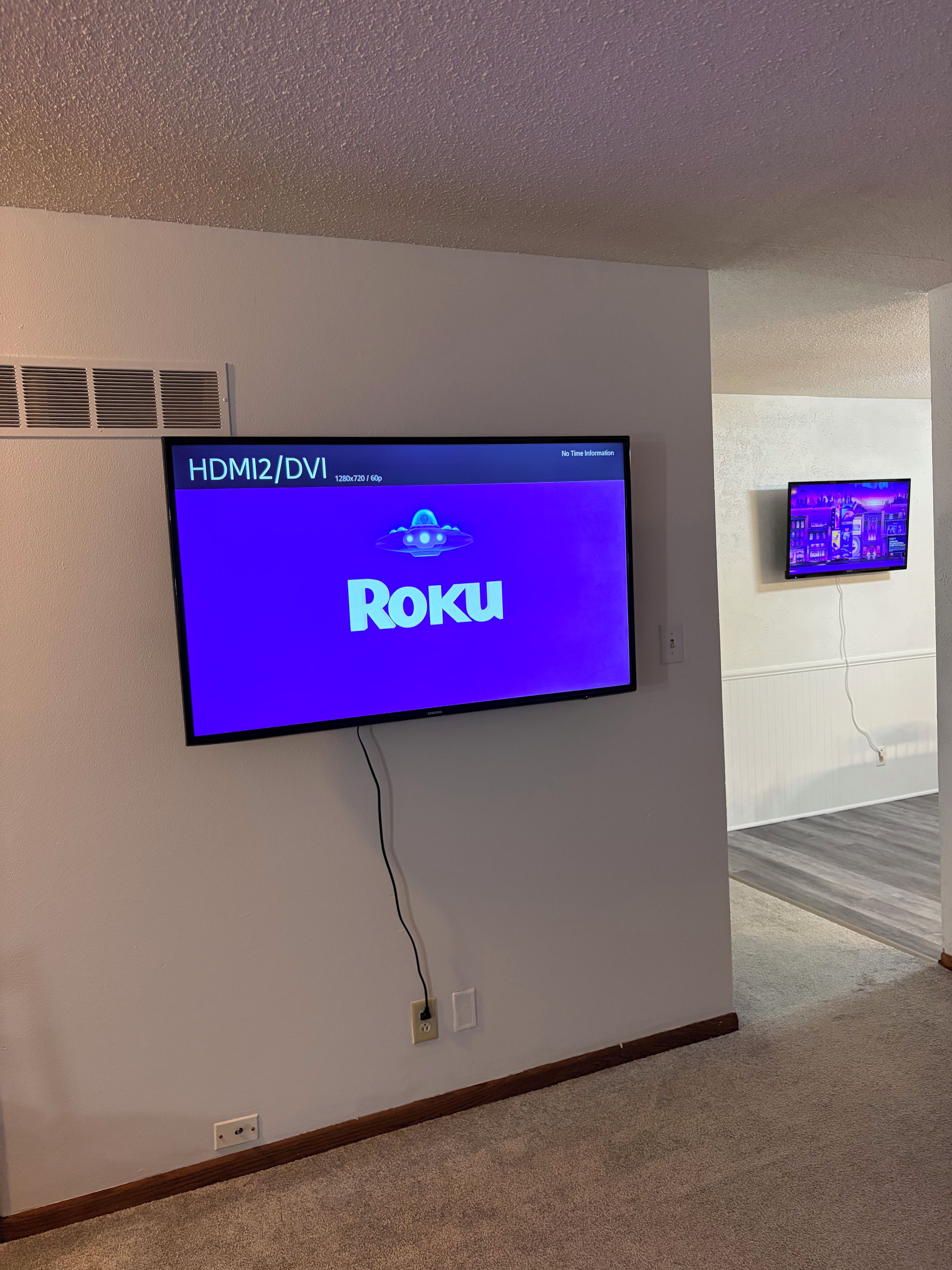 Un televisor de pantalla plana montado en la pared mostrando la interfaz de Roku.