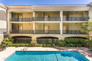 A multi-story hotel with balconies, a swimming pool, and a landscaped garden. - Half a Mile to the Pier and Village! (St. Simons Island)