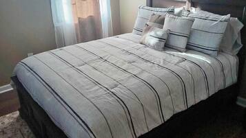 Ein Schlafzimmer mit Bett, Vorhängen und Kopfteil.