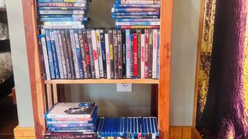 Estante de madeira com várias prateleiras cheias de DVDs e livros.
