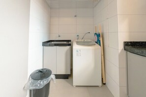 Pieni keittonurkkaus, jossa on pesuallas, mikroaaltouuni ja roskakori.