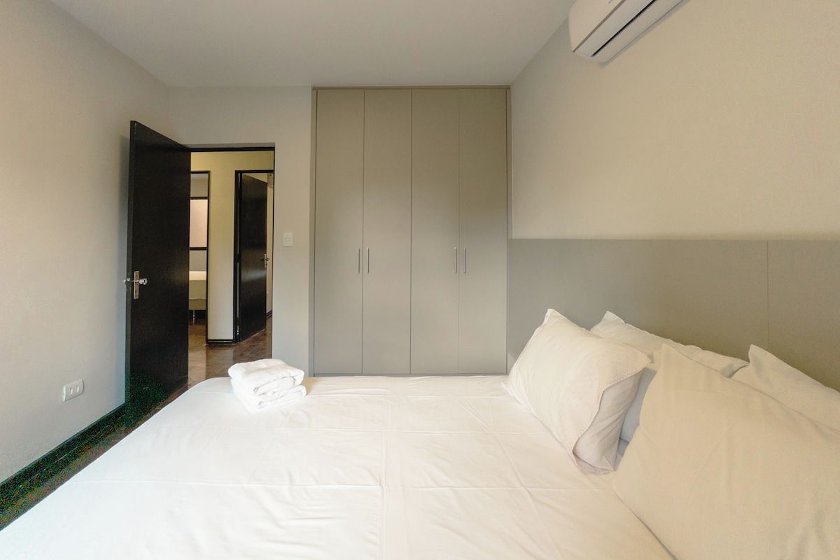 Ein Hotelzimmer mit einem Bett, einem Kleiderschrank und einer Klimaanlage.