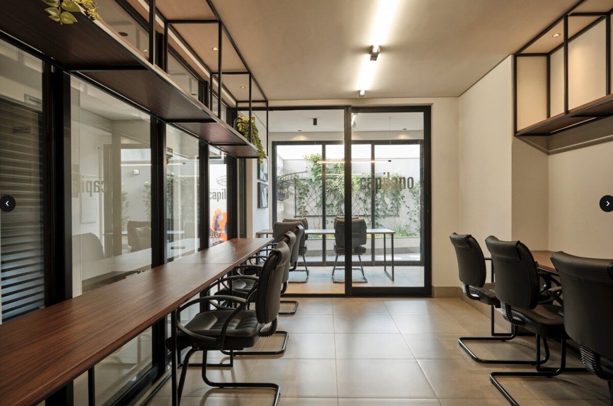 Une salle de réunion moderne, dotée d’une longue table et de chaises, de grandes fenêtres et offrant une vue sur l’extérieur.