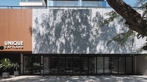 Un edifici amb façana moderna, una entrada ampla de vidre i un rètol que diu 'UNIQUE CAPILANO'.