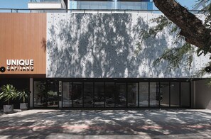Rakennuksessa on moderni julkisivu, suuri lasinen sisäänkäynti ja kyltti, jossa lukee: ”UNIQUE CAPILANO”.